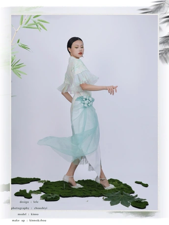 一位穿着蓝色连衣裙 裙子上饰有绿色叶子的模特