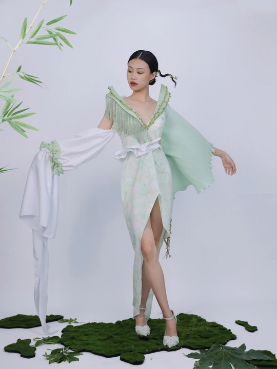 穿着绿色裙子的仙女模特的白色背景上摆姿势