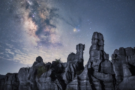 在夜晚星空下的山岩石上