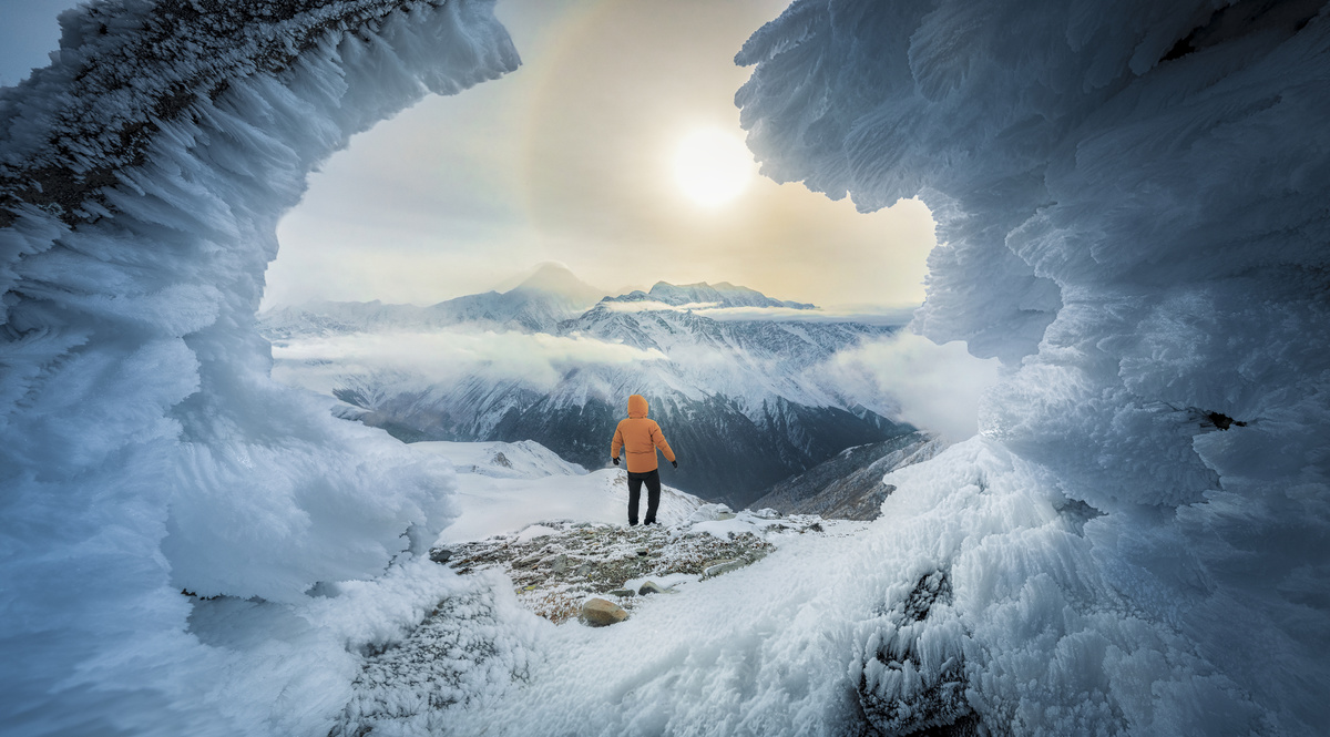 一个人站在洞穴里向外看冰川