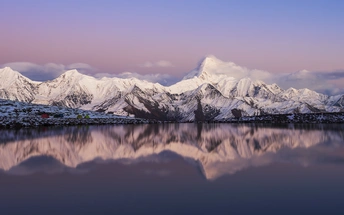 雪山上反射着夕阳下的静谧湖泊。