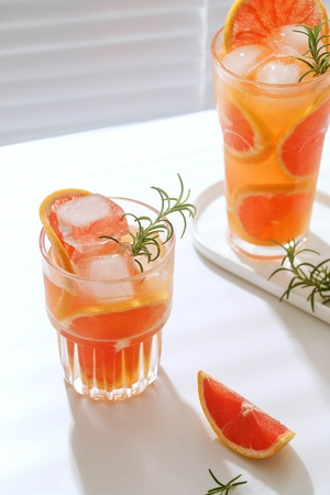 橙汁和迷迭香在玻璃杯中调制的鸡尾酒
