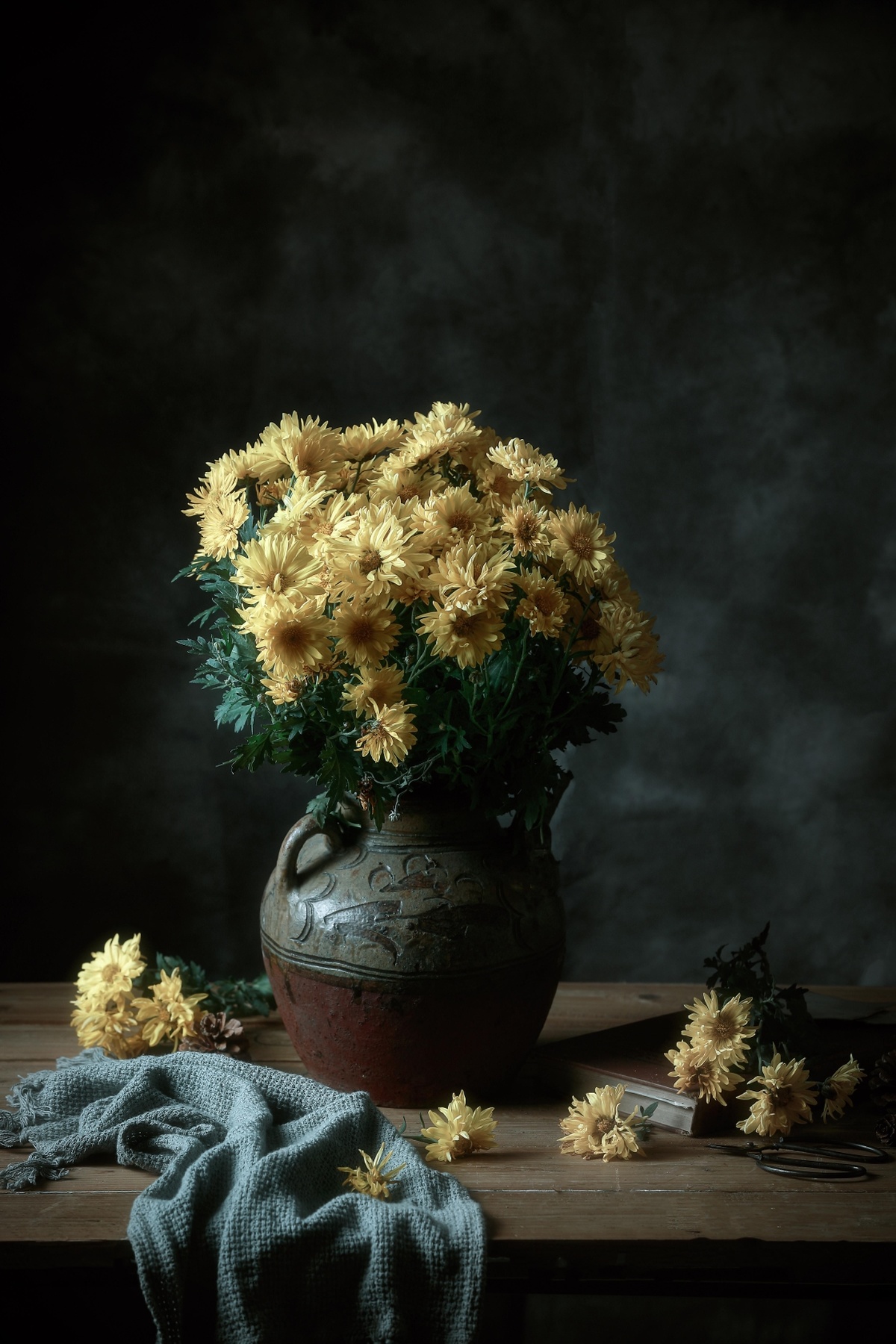 一个木桌上放着一个装满黄色花的花瓶
