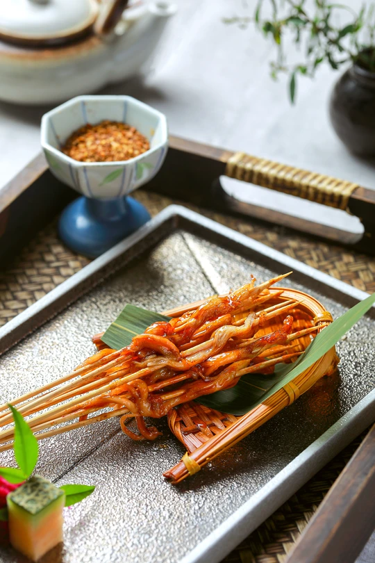 一盘食物 用筷子夹着 还有一些面条在棍子上