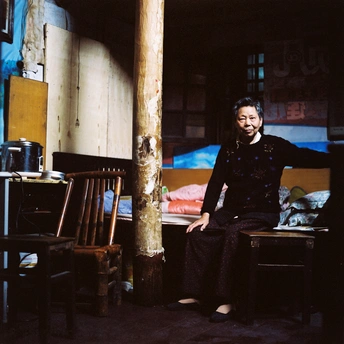 一个女人坐在房间的椅子上 一个男人坐在桌子旁