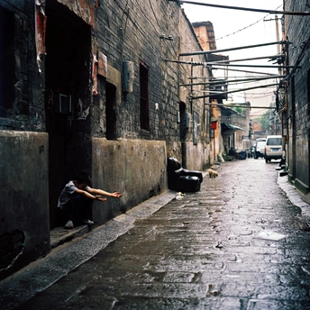 一条狭窄的小巷 一名男子坐在路边打伞