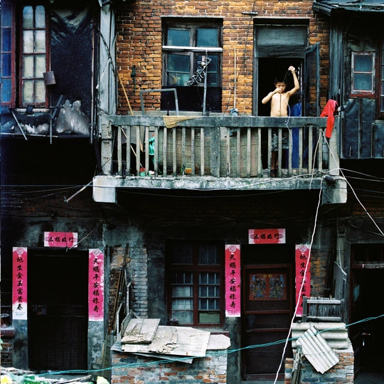 一个男人站在一栋旧建筑的阳台上