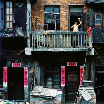 一个男人站在一栋旧建筑的阳台上