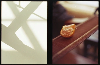 一只橙子放在一个木制桌子顶部 旁边是窗户。