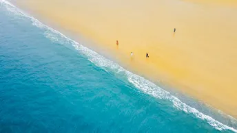 沙质海滩的 aerial view 带有蓝色海水