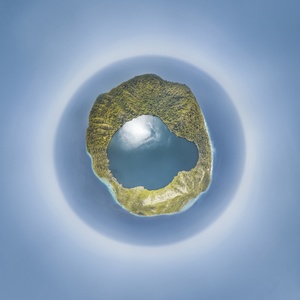 一个中心有洞的行星的3D渲染 周围被蓝色水域和云环绕着一座小岛