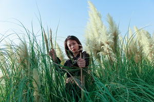 站在一片高草丛中的年轻女子