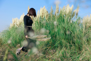 一位妇女穿过一片高草丛生的田野