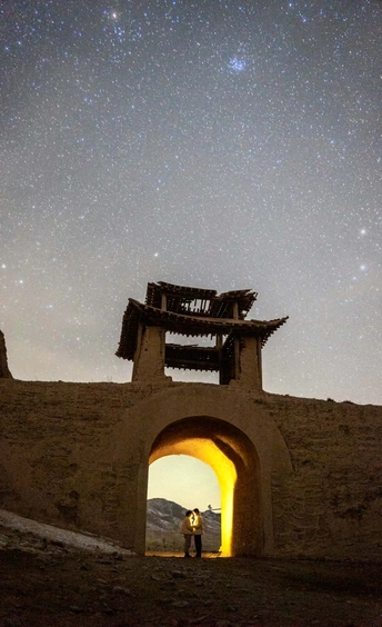 夜晚在石拱下接吻的一对情侣 天空中繁星闪烁。