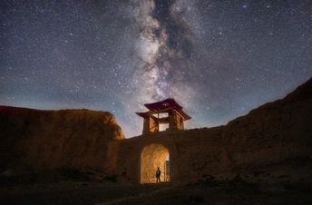 在沙漠中站着的人 在星空下。