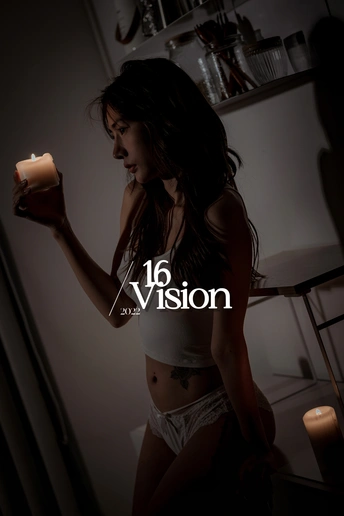 一个年轻女子手里拿着一支点燃的蜡烛 在一个光线昏暗的房间里。