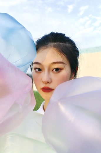 一个穿着白色连衣裙的年轻女子手里拿着一个蓝色气球