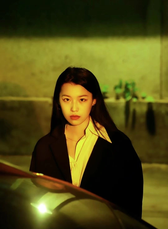 站在一辆绿色汽车旁的年轻女子