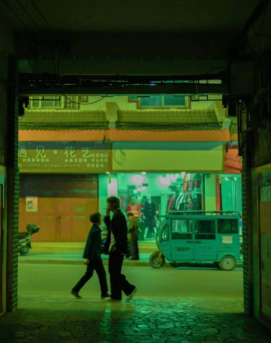 一些人在一栋建筑旁边的一条街上走。