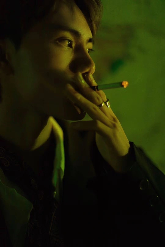 一个年轻人在绿色房间里抽烟