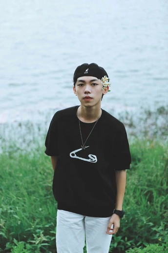 一个穿着黑色衬衫的年轻人站在一个水体附近