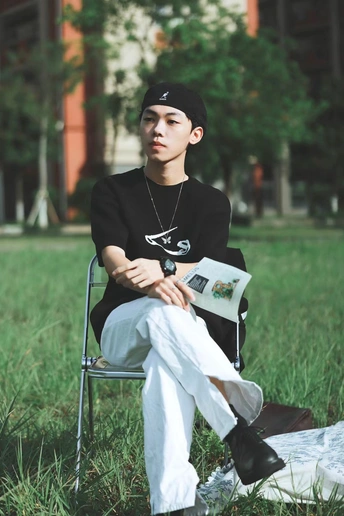 一个坐在草地上的椅子上的年轻人