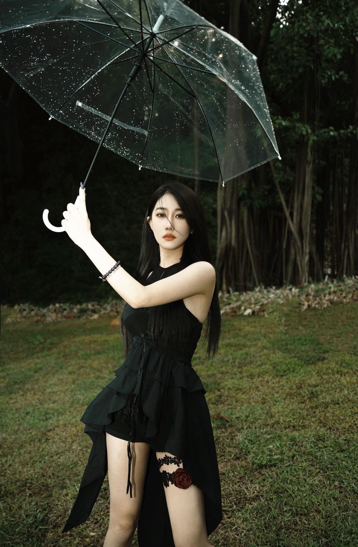 一个穿黑色连衣裙的女人拿着一把伞