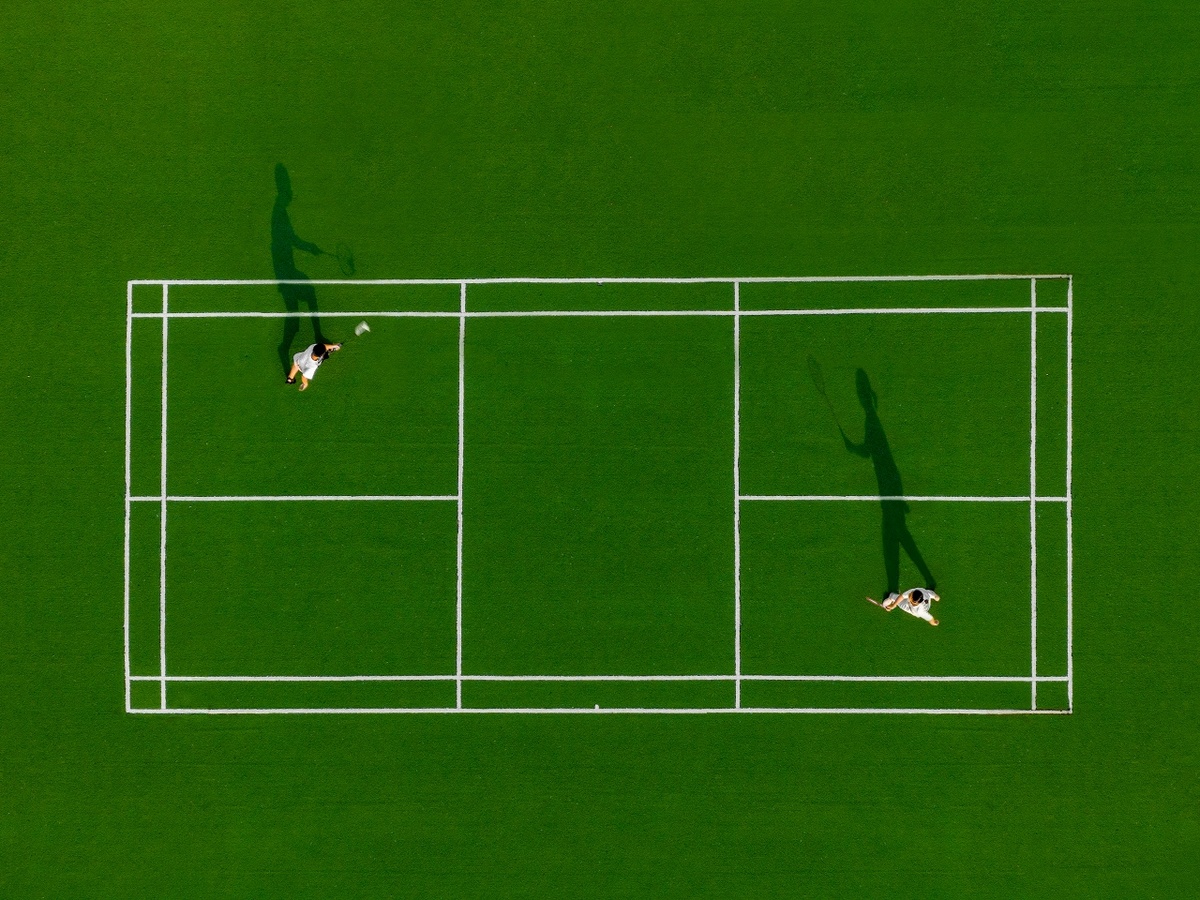 一些人正在绿地上打网球。