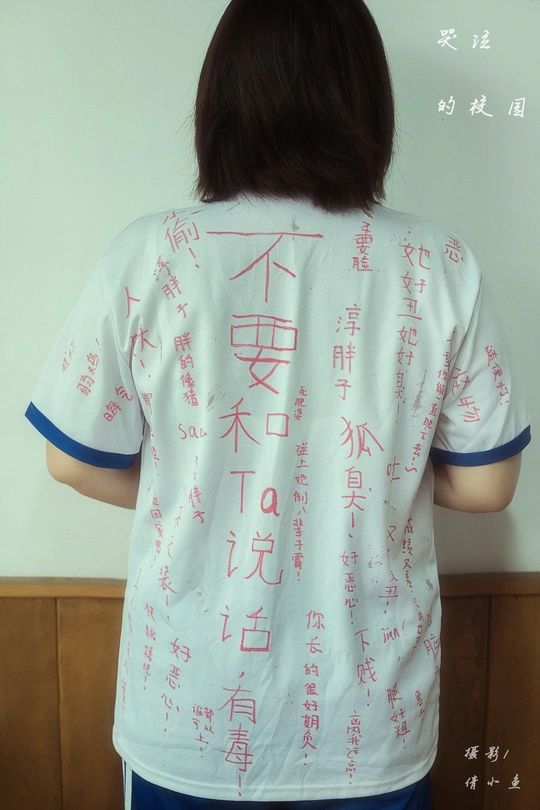 一位穿着白色衬衫 上面有中文文字的女性