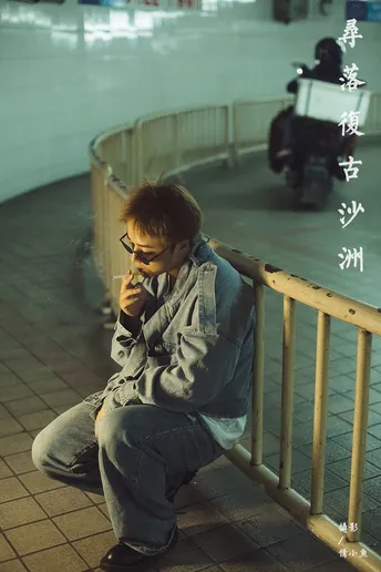 一个戴眼镜的年轻人正在抽烟并看着他的手机