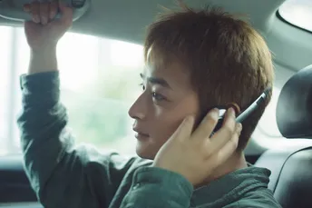 一个年轻人开车打电话坐在副驾驶座位上