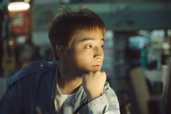 一个年轻人坐在公交车上看着他的手机