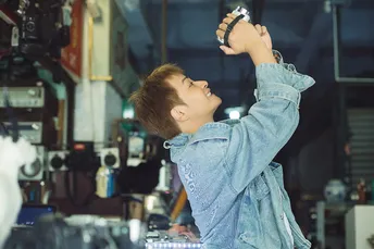 一位年轻女子在一个商店里拿着一个杯子工作