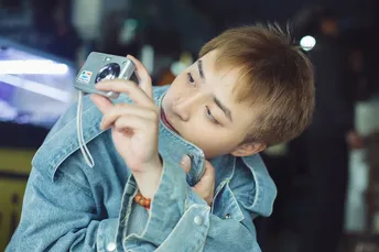 一个年轻男孩正在打电话并看着相机