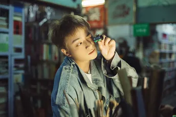 一个男孩拿着一个玻璃在看手机