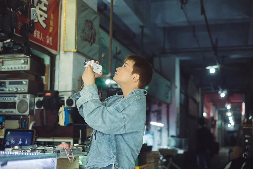 一个年轻男子站在工厂里喝着一瓶水