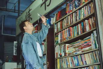 一个小女孩站在图书馆的书架前