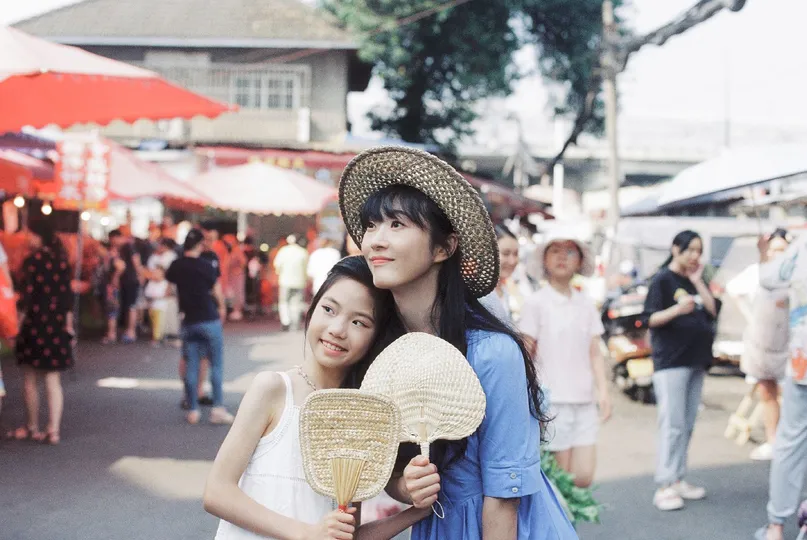 一对年轻女性戴着帽子走下街道