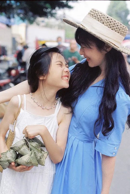 蓝色连衣裙的年轻女子抱着一个年轻女子