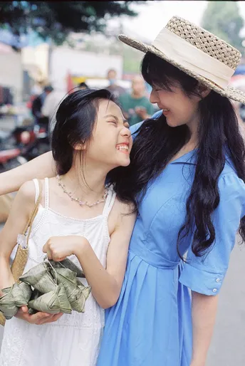 蓝色连衣裙的年轻女子抱着一个年轻女子