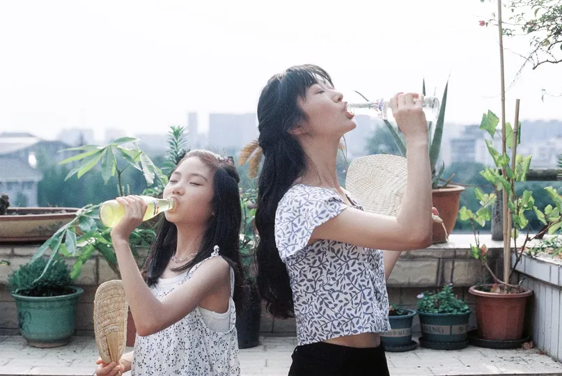 一个年轻女子和一个小女孩正在瓶子和玻璃杯中喝水。