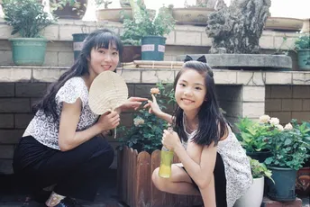 两个年轻女孩在花盆前摆姿势