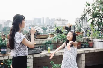 一位年轻女子站在屋顶上 小女孩在玩耍。