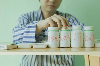 一个年轻男子坐在桌子前 桌子上放着瓶装牛奶。