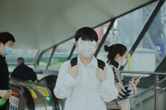 周一 中国香港的机场 一位戴口罩的女士站在自动扶梯上 人们戴口罩是为了保护他们的脸免受传播。