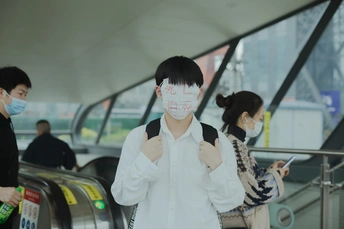 周一 中国香港的机场 一位戴口罩的女士站在自动扶梯上 人们戴口罩是为了保护他们的脸免受传播。