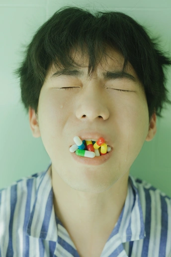 一个嘴里含着药丸 眼睛里满是糖果的年轻人
