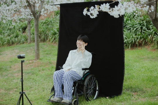 一位坐在轮椅上的女人在黑色屏幕前