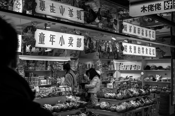 一张黑白照片 人们在一家商店里购物 购买食物。