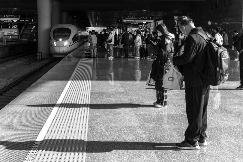 一张黑白地铁站的照片 有 couple of 人在站台上站着。